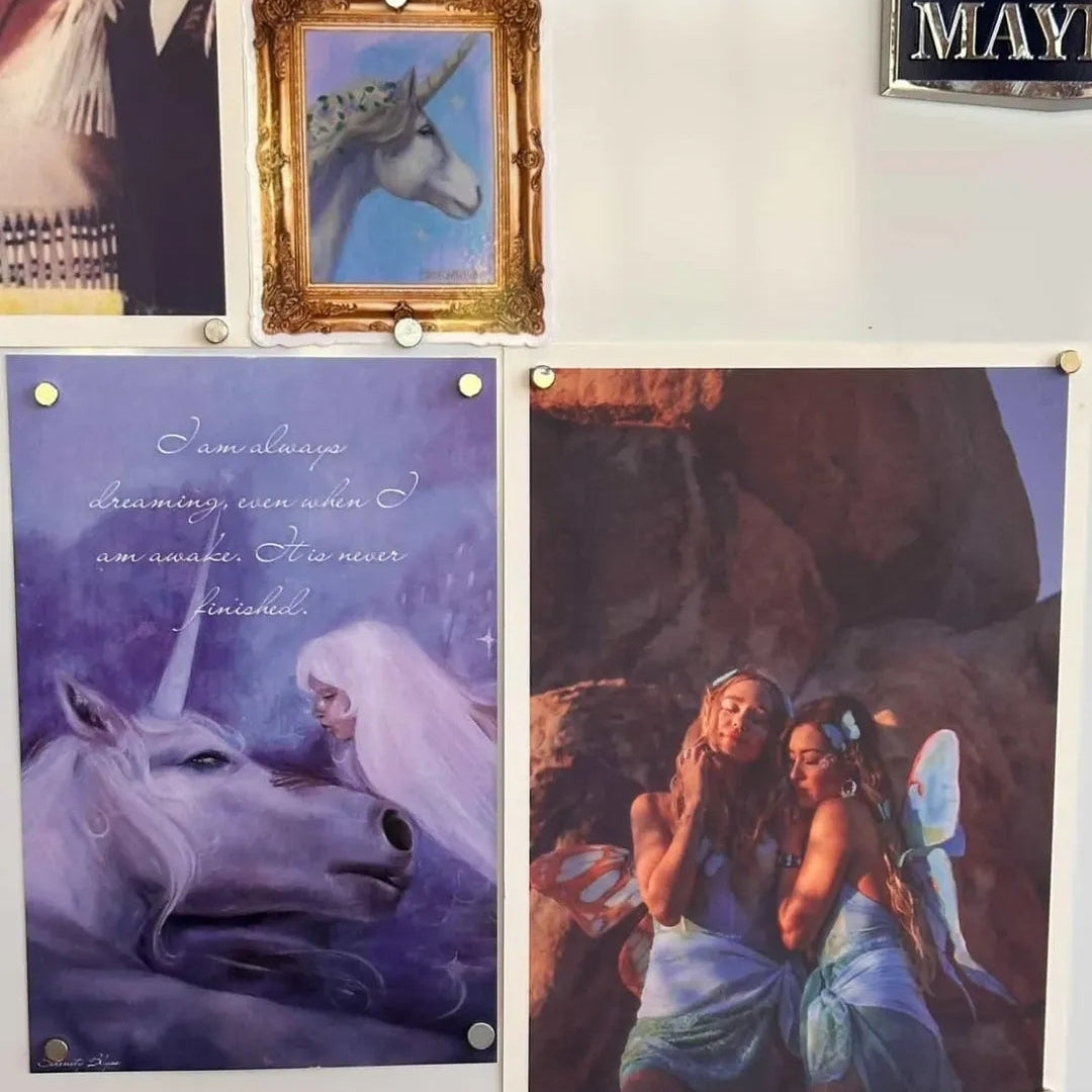 Framed artwork of unicorns and fairies on a refrigerator with a message.